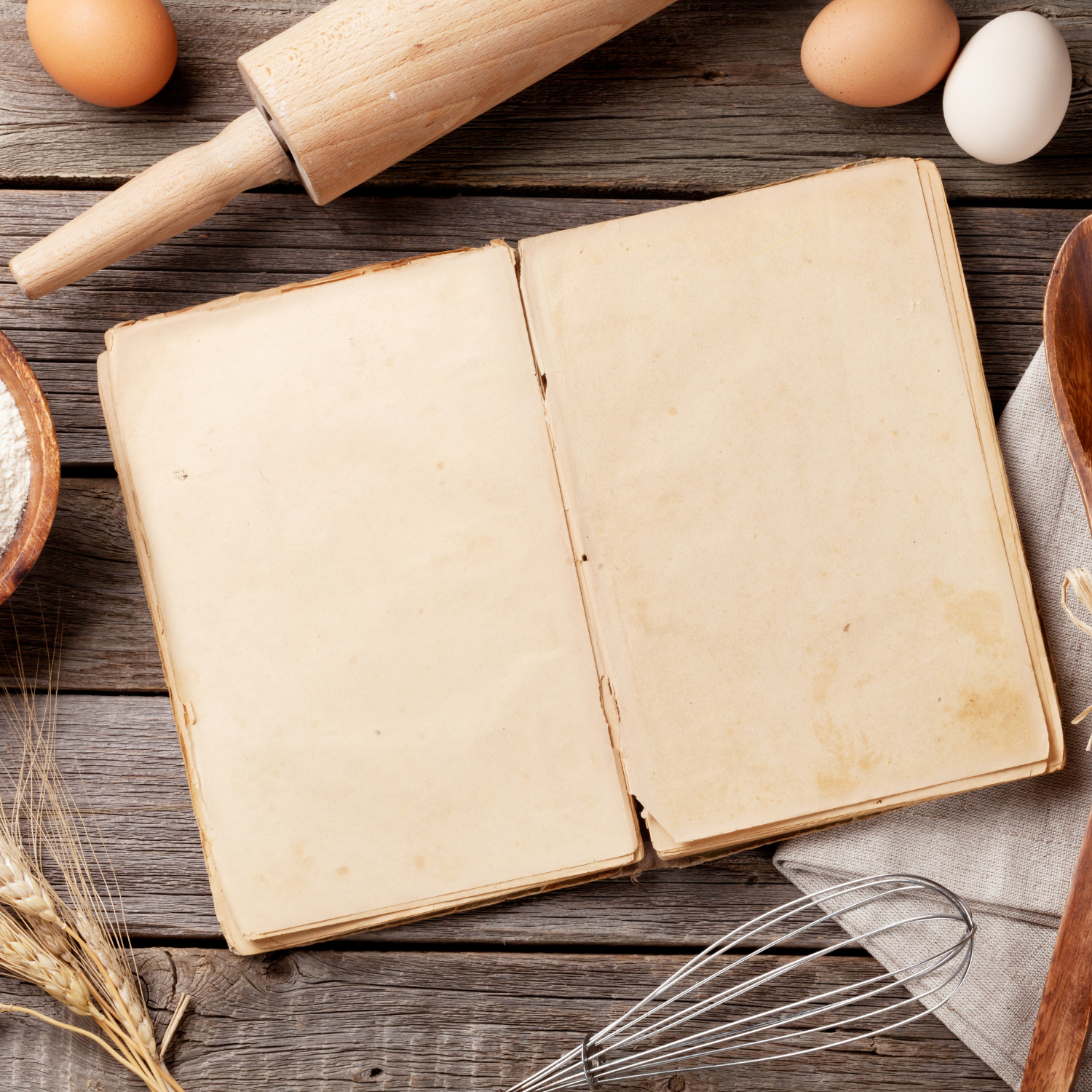 blank recipe book, rolling pin, eggs and a whisk to cook